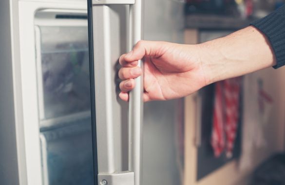 33455170 - the hand of a young man is opening a freezer door
